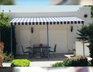 Residential patio shade awning with blue and white striped awning fabric