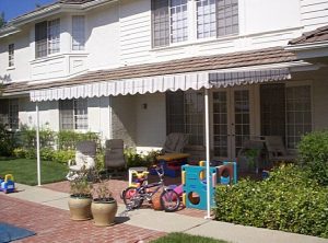 Residential patio shade awning with striped awning fabric