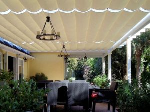 Residential slide on wire awning with white awning fabric and custom outdoor chandeliers