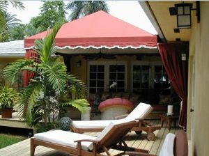 Residential patio shade awning with red and white awning fabric