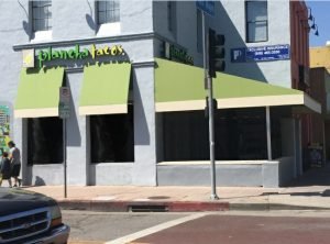 Light green and yellow storefront awning for Plancha Tacos