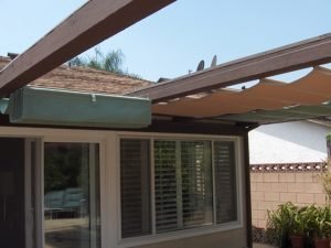 Residential slide on wire awning with green and gold awning fabric