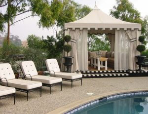 Custom pool cabana with beige awning fabric and custom drapes