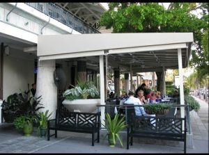 Beige storefront awning with white beams on a patio