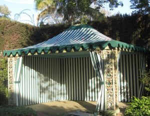 Residential cabana with striped green and white awning fabric