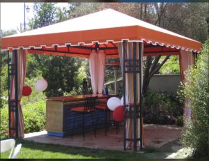 Residential cabana with orange awning fabric and custom drapes