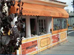 Custom orange storefront awning for Soleil French Bistro