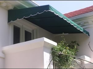 Green patio shade awning with white awning fabric accents