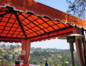 Residential cabana with orange awning fabric over an outdoor bar