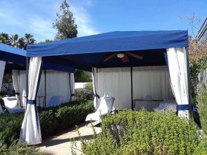 Custom cabana with blue awning fabric and white custom blinds