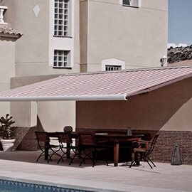 Striped retractable awning next to a pool